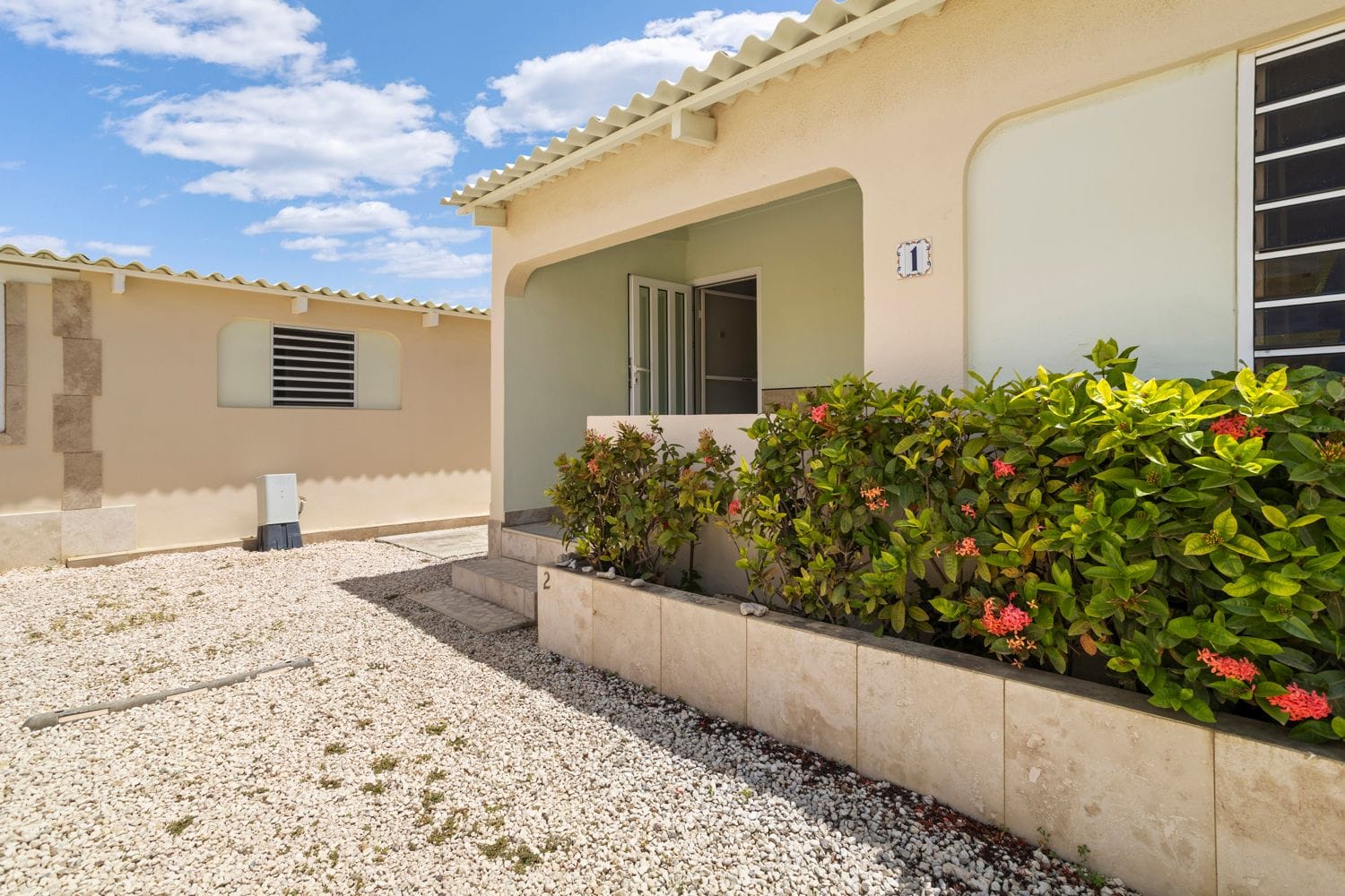 Bungalow mit Veranda und blühender Hecke
