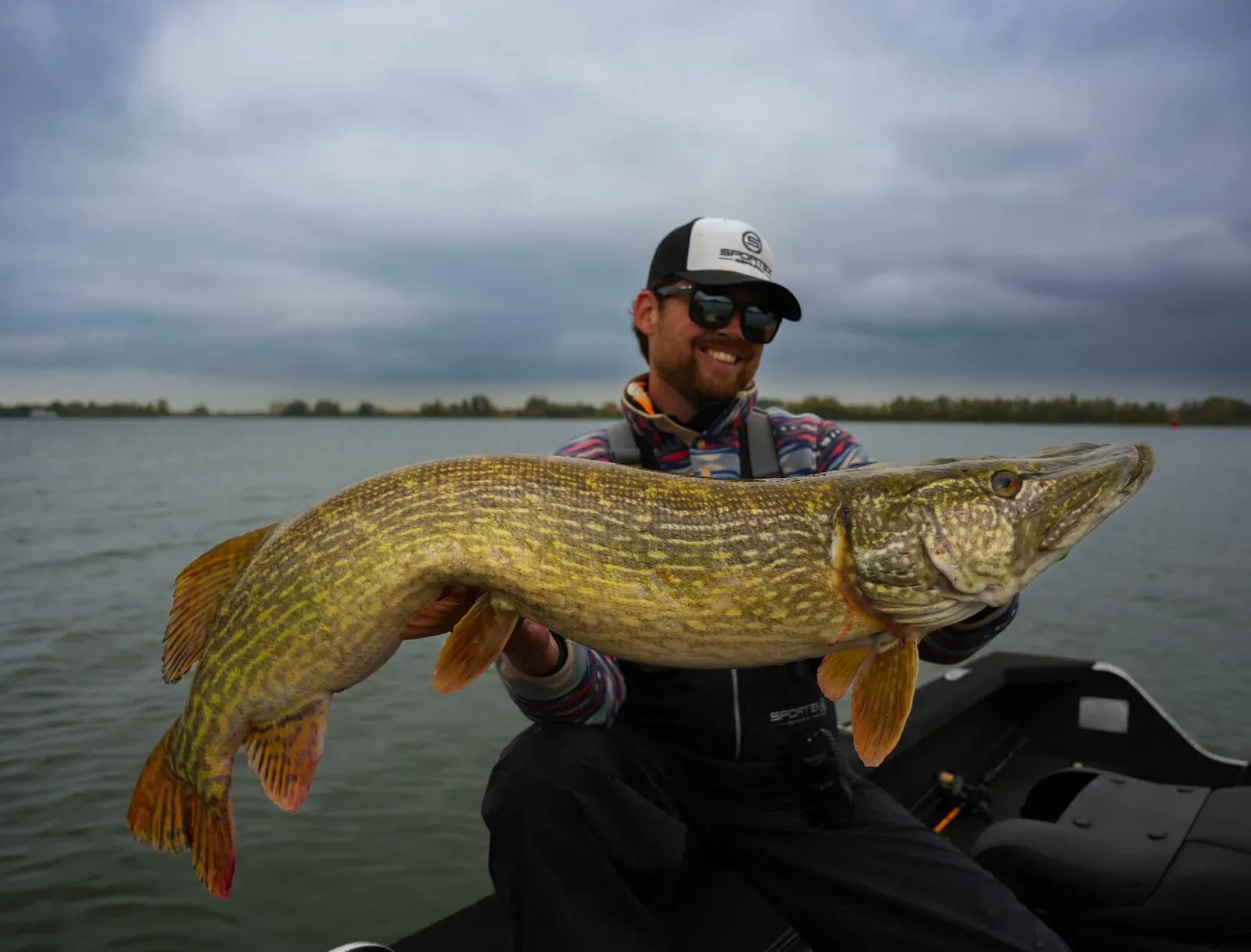 Een grote snoek, van dichtbij vastgehouden vanaf de boot op het open water van de delta