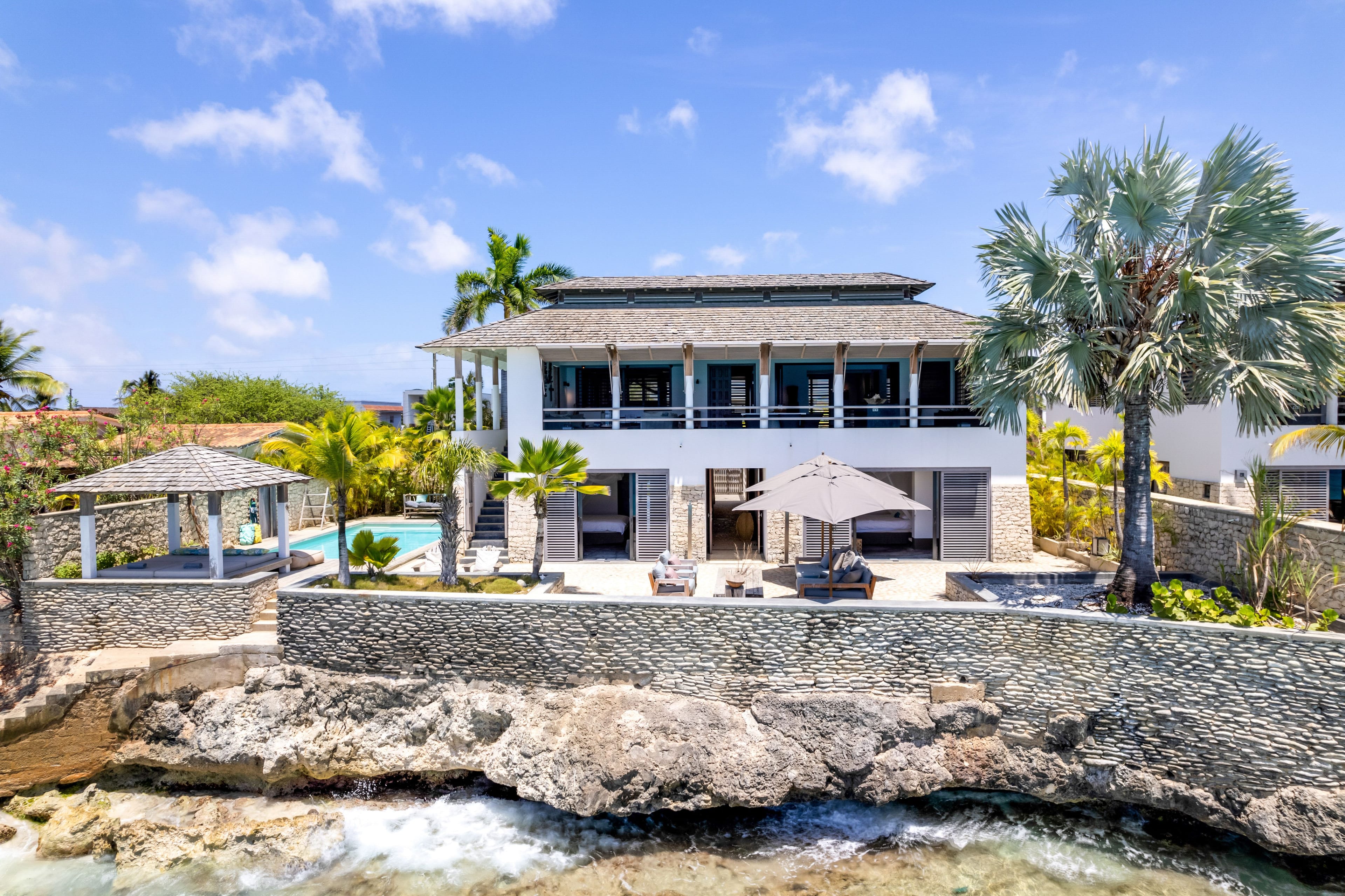 Villa Mi Casa Bonaire vanaf zee, met het terras en het zwembad aan de waterkant